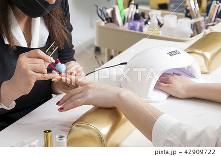 Nail salon woman hands treatment. Nail saloon woman painting color nail polish in hands stock photo. 054 Nail salon woman hands treatment. Nail saloon woman painting color nail polish in hands stock photo. 054 42909722