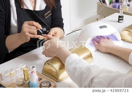 Nail salon woman hands treatment. Nail saloon woman painting color nail polish in hands stock photo. 049 Nail salon woman hands treatment. Nail saloon woman painting color nail polish in hands stock photo. 049 42909723