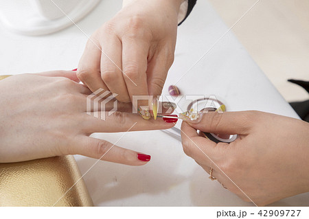 Nail salon woman hands treatment. Nail saloon woman painting color nail polish in hands stock photo. 060 42909727