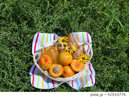 tasty fruits and bottle of juice in wicker basket  42910776
