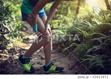 Female runner suffering with pain on sports running knee injury 42913871