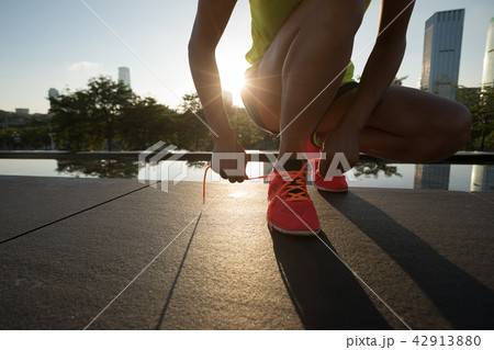 woman runner tying shoelace before running 42913880