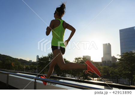fitness woman runner running at sunrise city 42913890