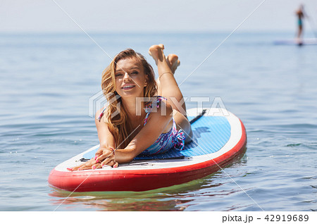 Young woman doing yoga on sup board ,  Mediatative pose,  concep 42919689