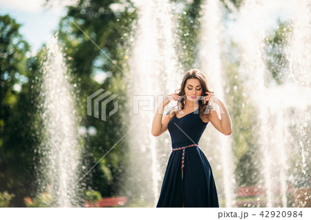 A girl is walking around the city, near a large fountain. Sunny day. Summer A girl is walking around the city, near a large fountain. Sunny day. Summer 42920984