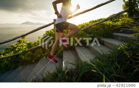 Determined woman running up on seaside   42921000