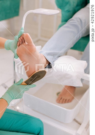 Man wearing grey jeans sitting and enjoying pedicure time 42921976