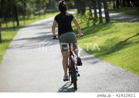 Woman riding mountain bike in tropical park 42922621