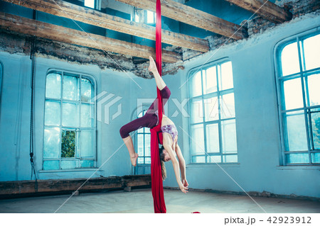 Graceful gymnast performing aerial exercise at loft 42923912