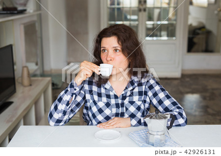 Young woman drinking coffee in the kitchen Young woman drinking coffee in the kitchen 42926131