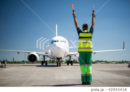 Aviation marshall raising hands and signaling 42933418