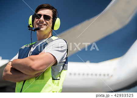 Cheerful airport worker crossing arms Cheerful airport worker crossing arms 42933525