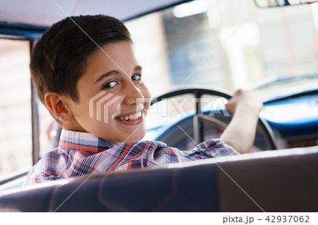 Portrait Child Taking Driving Lesson In Old Car Smiling 42937062