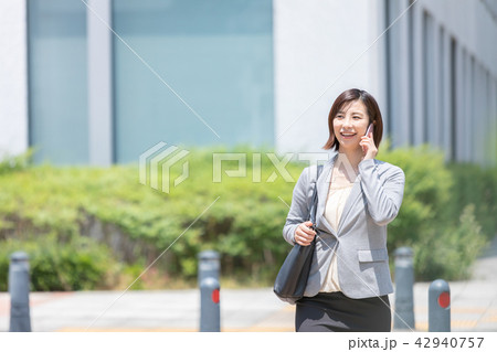 ビジネス街を歩く女性　オフィスレディ　出張中　新緑　OL　ビジネス　スーツ　ポートレート　リクルート 42940757