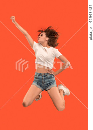 Freedom in moving. Pretty young woman jumping against orange background Freedom in moving. Pretty young woman jumping against orange background 42943482