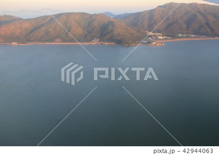view of plane window looking down of a land 42944063