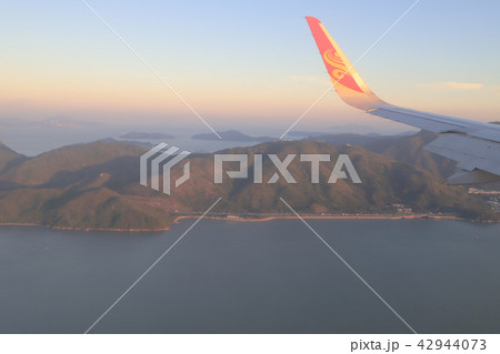 view of plane window looking down of a land 42944073