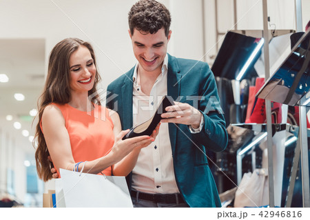 Man and woman thinking about buying pair of shoes Man and woman thinking about buying pair of shoes 42946816
