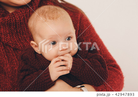 baby on the hands of parents biting his pen baby on the hands of parents biting his pen 42947893