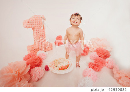 a little girl eats cake with her hands.  42950882