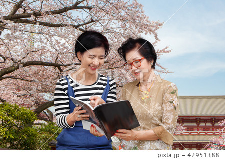 Senior woman reading guidebook with her daughter 42951388
