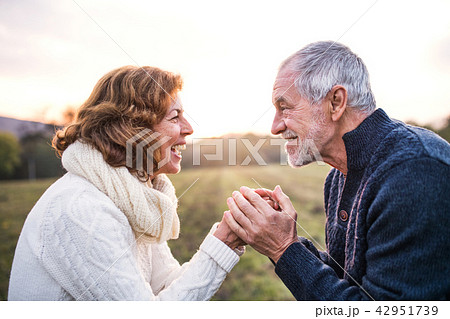 Senior couple looking at each other in an autumn nature, holding hands. Senior couple looking at each other in an autumn nature, holding hands. 42951739