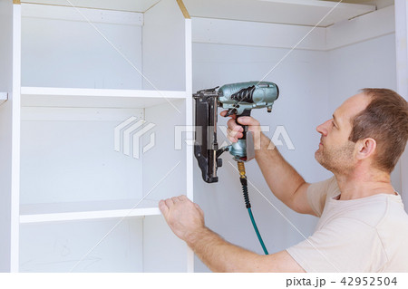 carpenters workers joint and wall installing shelf carpenters workers joint and wall installing shelf 42952504