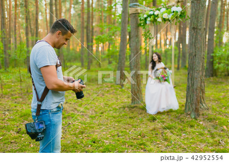 Photographer taking pictures of the bride on a rope swing Photographer taking pictures of the bride on a rope swing 42952554