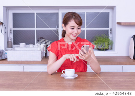 珈琲を飲みながらスマホを見る女性 42954348