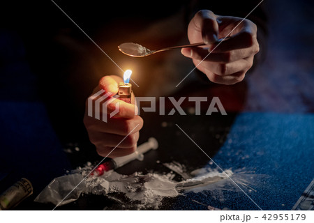Junkie hand preparing heroin dose. Drug addiction 42955179