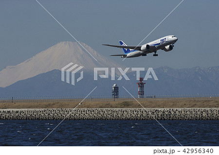 富士山を背に羽田空港d滑走路を離陸するb787の写真素材