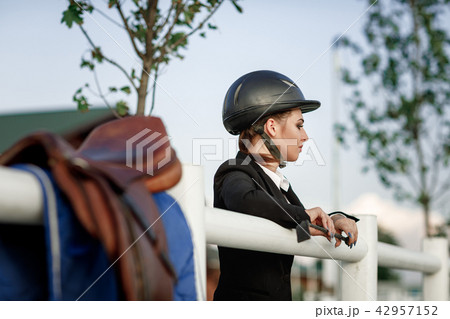 elegant rider woman in helmet with whip 42957152