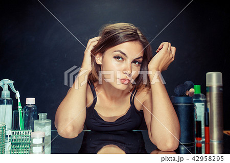 Beauty woman after applying makeup. Beautiful girl looking in the mirror and applying cosmetic with Beauty woman after applying makeup. Beautiful girl looking in the mirror and applying cosmetic with 42958295