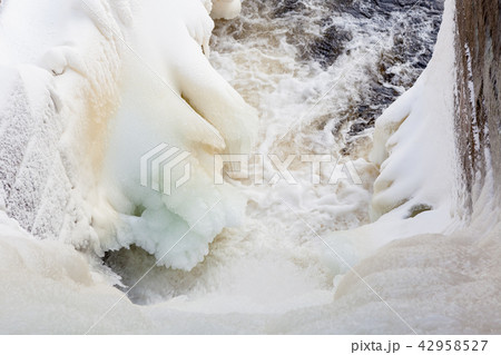 Dam at winter flowing water and ice 42958527
