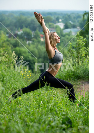Young girl doing yoga on the glade profile shot Young girl doing yoga on the glade profile shot 42958894