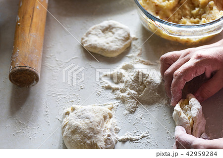 Forming a pie with potatoes by women's hands 42959284