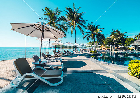 Beautiful tropical beach and sea with umbrella and chair around swimming pool Beautiful tropical beach and sea with umbrella and chair around swimming pool 42961983