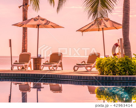 Umbrella and chair around luxury outdoor swimming pool Umbrella and chair around luxury outdoor swimming pool 42963414