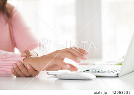 Woman holding her wrist pain from using computer 42968285