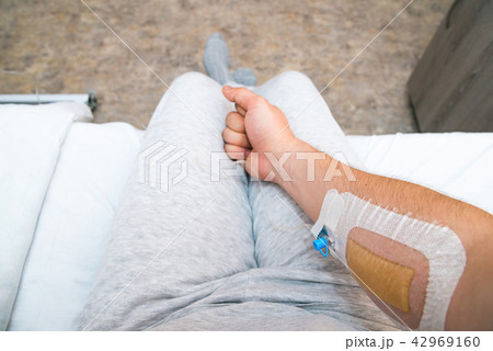 Patient's hand with fist with Infusion catheter 42969160