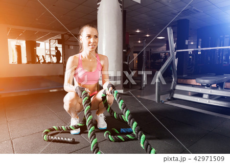 slim girl doing exercises with a cable at the gym slim girl doing exercises with a cable at the gym 42971509