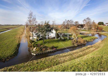 Dutch polder landscape with a farm and some houses Dutch polder landscape with a farm and some houses 42972033