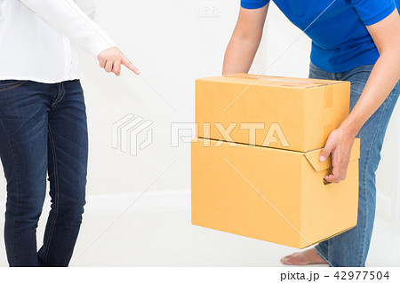 Woman receiving package from delivery man Woman receiving package from delivery man 42977504