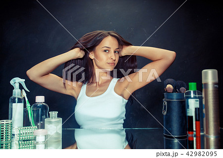 Beauty woman after applying makeup. Beautiful girl looking in the mirror and applying cosmetic with Beauty woman after applying makeup. Beautiful girl looking in the mirror and applying cosmetic with 42982095