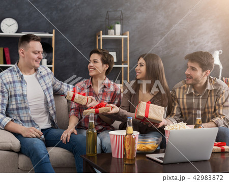 Friends celebrating birthday and giving gifts at home 42983872