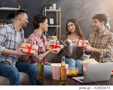 Friends celebrating birthday and giving gifts at home 42983874