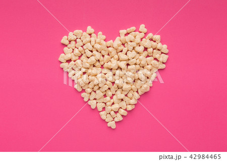 Heart made cereals on a pink background Heart made cereals on a pink background 42984465