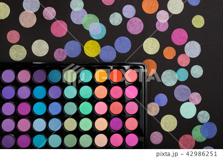 Colorful make-up palette with confetti on black background. Top view 42986251