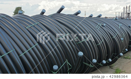 Warehouse of finished plastic pipes industrial outdoors storage site. Manufacture of plastic water Warehouse of finished plastic pipes industrial outdoors storage site. Manufacture of plastic water 42986364