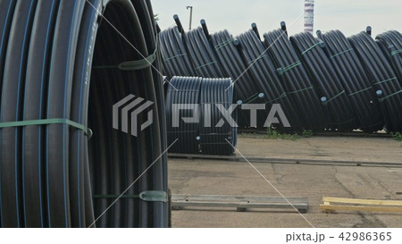 Warehouse of finished plastic pipes industrial outdoors storage site. Manufacture of plastic water Warehouse of finished plastic pipes industrial outdoors storage site. Manufacture of plastic water 42986365